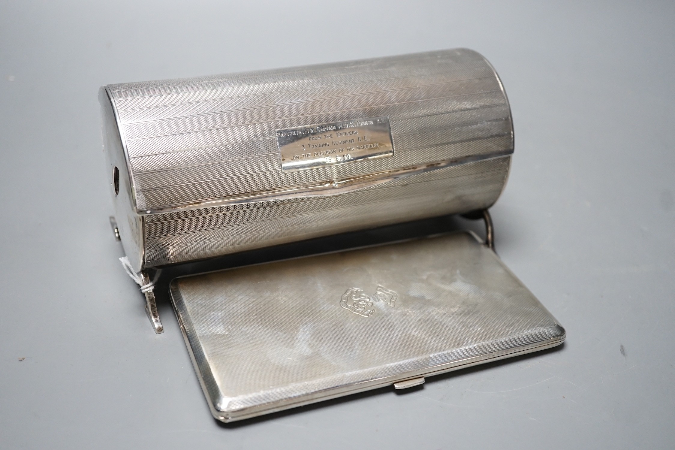 A George V engine turned cylindrical twin compartment cigarette box, with revolving cover, London, 1928, 17.1cm, with engraved inscription, together with a later large engine turned silver cigarette case, gross 21.5oz.